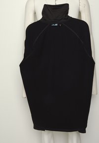 Vestido negro de punto con un cuello alto, hecho de un tejido suave. Presenta mangas raglán y un corte holgado, con un diseño minimalista.