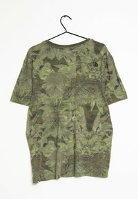 Camiseta de camuflaje verde con mangas cortas, hecha de tela suave. Presenta un logo negro en la parte superior izquierda y un corte cómodo.