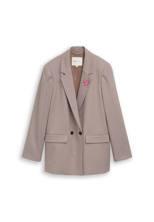 Blazer à carreaux marron clair avec deux boutons noirs, poches à rabat, et une épingle en forme de cœur rose sur le revers gauche.