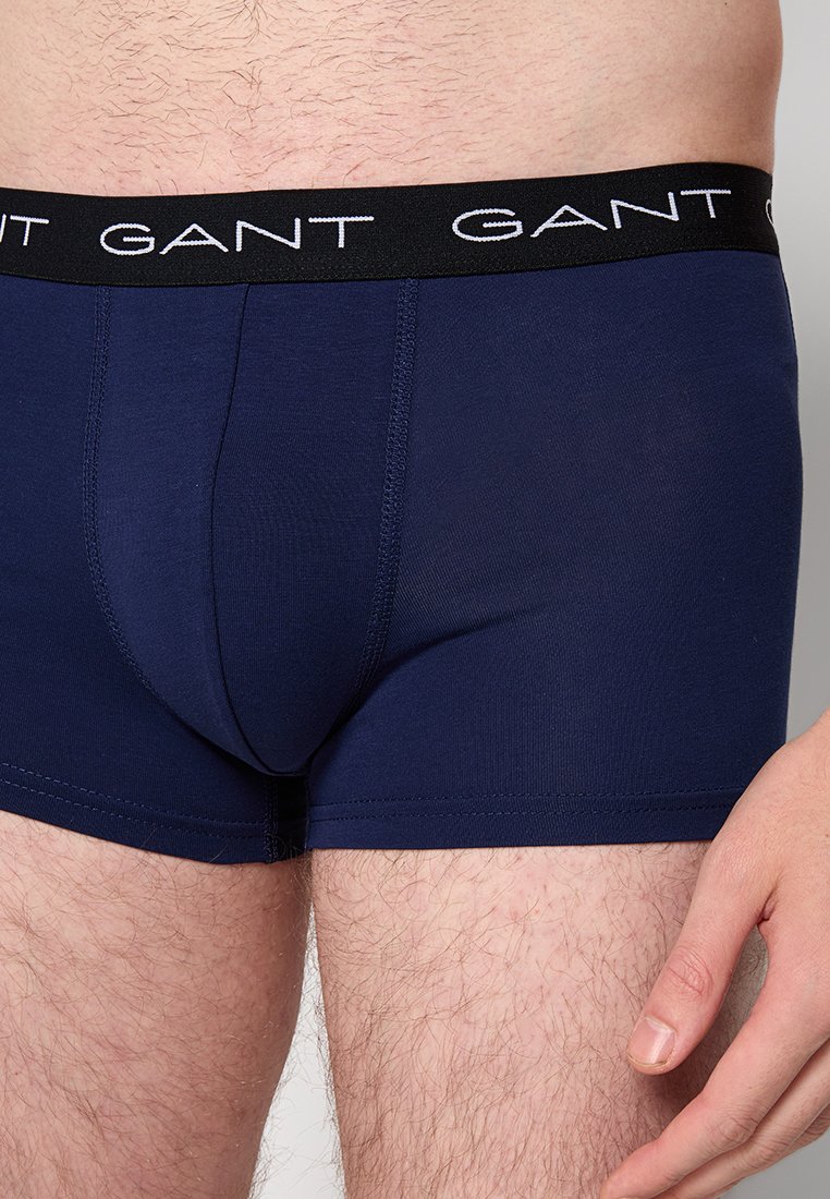 Boxer da uomo blu navy realizzati in un tessuto elastico. Presentano una cintura nera con il logo "GANT" in bianco. Tessuto liscio, design a vestibilità aderente.