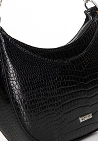 Schwarze Handtasche aus Kunstleder mit Krokodilprägung, abgerundeter Form, silbernem Reißverschluss und Metall-Logo-Akzent.