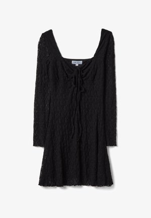 Mini abito nero in pizzo con maniche lunghe, scollo quadrato e dettaglio con fiocco sul davanti, aderente al busto e svasato nella gonna.