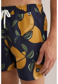 Herren Schwimmshorts in Marineblau, mit einem gelb-grünen Zitronenmuster. Elastischer Bund mit Kordelzug und seitlichem Logo-Detail.