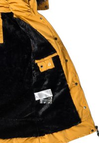 Yellow padded jacket with a black faux fur lining. Features a pocket with a headphone logo and contains product information and keys.