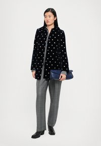 Merenkukkainen samettitakki, harmaa pitkähihainen paita, ruudulliset housut ja teksturoitu sininen clutch. Mustat nilkkurit viimeistelevät asun.