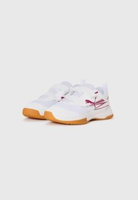 Baskets blanches avec semelles orange, straps velcro, et logo Puma rouge sur les côtés, présentées sur un fond blanc uni.