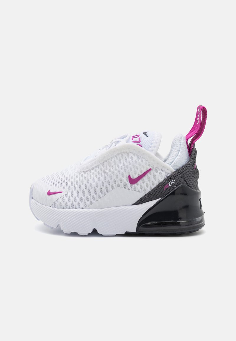 Zapatilla deportiva blanca con parte superior de malla, acentos morados y talón negro. Presenta una suela acolchada y una pestaña en el talón para facilitar su uso.