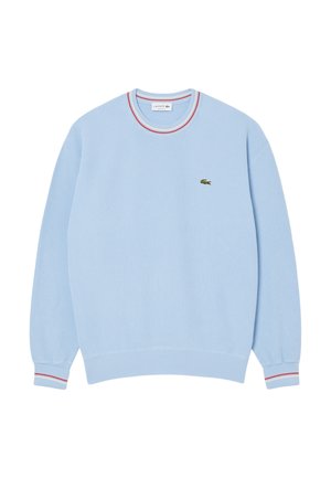 Sudadera de color azul claro con cuello redondo, puños acanalados y un cuello a rayas multicolores. Presenta un pequeño logo verde en el pecho.