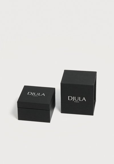 Deux boîtes à bijoux noires DJULA Paris, une fermée et une ouverte, exposées sur une surface blanche.