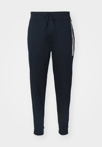 Marine joggebukser i myk stoff med snor i livet, avsmalnende mansjetter og en sidestripe med logo-detaljer.