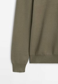 Sweter z dzianiny w oliwkowej zieleni, z okrągłym dekoltem, ściągaczami przy mankietach i dolnym brzegu. Materiał ma miękką fakturę i gładkie wykończenie.