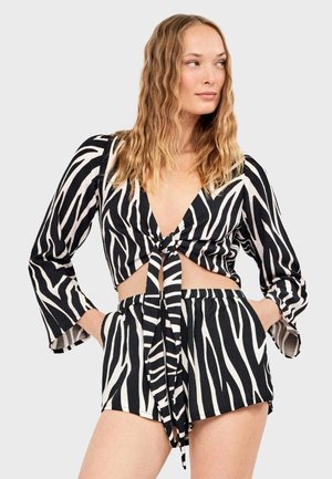 Schwarz-weiß gestreiftes Crop-Top mit V-Ausschnitt und Bindeband vorne, kombiniert mit passenden, hoch taillierten Shorts mit elastischem Bund.