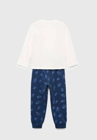 Bílá bavlněná blůza s dlouhým rukávem kombinovaná s námořnickými kalhotami s potiskem modrých kreslených postaviček. Kalhoty mají elastické manžety na kotnících.