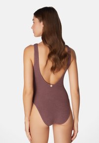 Ribbed brauner Badeanzug mit tiefem Rückenschnitt, breiten Trägern und einem einzelnen Knopfdetail am unteren Rücken. Glatte Textur, figurbetontes Design.