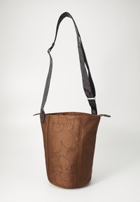 Sac seau en cuir marron avec un motif floral embossé, sangle noire réglable avec un design subtil et fermeture à glissière.