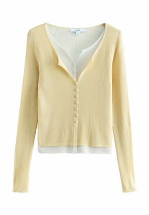 Hellgelber, gerippter Cardigan mit langen Ärmeln, vorne mit Knöpfen, und geschichtetem weißen Innenstoff, der am Ausschnitt und Saum sichtbar ist.