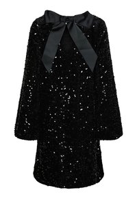 Czarna sukienka z długim rękawem, pokryta cekinami, z dekoltem w kształcie litery V i dużą czarną kokardą zawiązaną na szyi.
