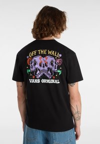 Camiseta negra de algodón con un gráfico de dos calaveras coloridas y el texto "OFF THE WALL" y "VANS ORIGINAL" en la parte posterior.