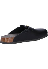 Schwarzer Slipper mit glatter Oberfläche, geschwungenem Design, Korkakzenten und einer strukturierten Gummisohle. Verfügt über einen seitlichen Riemen mit einem Knopf.