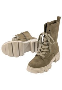 Botas de tobillo de ante verde con cordones, suela gruesa color crema y cremallera lateral para mayor facilidad. Presentan ojales metálicos y una superficie texturizada.