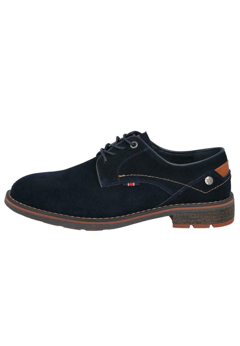 Zapato de ante azul marino con un detalle marrón en el talón, costuras de contraste y una suela de goma texturizada. Presenta un pequeño detalle del logo.