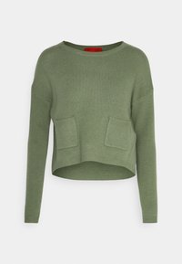 Maglione corto verde in tessuto lavorato a maglia, con maniche lunghe e due tasche frontali. Il collo è rotondo e i bordi sono ribattuti.
