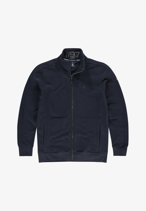 Veste bleu marine à fermeture éclair complète avec col haut, manches longues, deux poches avant, et petit logo sur le côté gauche de la poitrine et la manche droite.