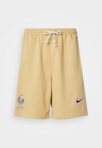 Żółte bawełniane szorty mają elastyczny pasek w talii z sznurkiem, fioletowe logo Nike oraz haftowany emblemat koguta z napisem "FFF".