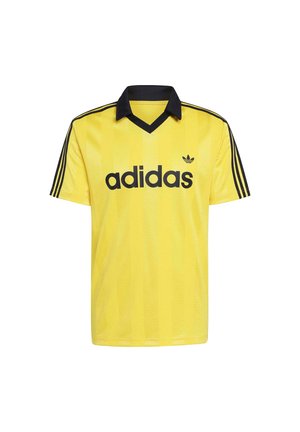 Camiseta deportiva amarilla de Adidas con cuello negro, tres franjas negras en las mangas y el logo y texto de Adidas en negro en el frente.