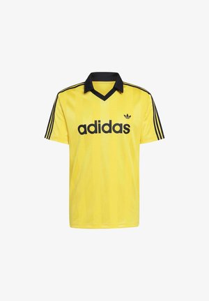 Camiseta deportiva amarilla de Adidas con cuello negro, tres franjas negras en las mangas y el logo y texto de Adidas en negro en el frente.