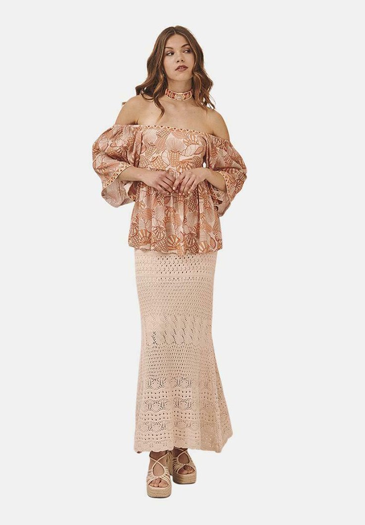 Blusa de flores melocotón sin hombros con mangas abullonadas, combinada con una falda maxi de ganchillo beige y cuñas de plataforma. Incluye un collar choker.