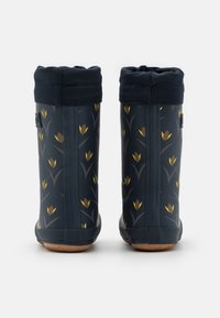 Bottes en caoutchouc imperméables bleu foncé avec un motif floral comportant des tulipes jaunes, une bordure texturée et un revers flexible en haut.