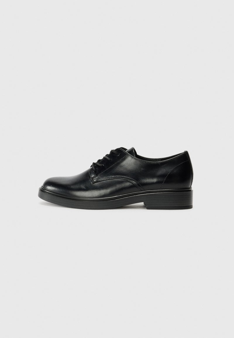 Chaussure oxford en cuir noir avec une finition lisse, un design à lacets, un bout arrondi et une semelle en caoutchouc texturée et basse.
