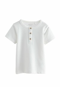 Fehér, rövid ujjú póló bordázott anyagból, kerek nyakkivágással és három fa gombbal az elején.