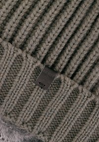 Gestrickte Wollmütze in mutedem Grau mit gerippter Textur; verfügt über ein dunkles Lederetikett mit geprägt Markenname. Dickes und warmes Design.