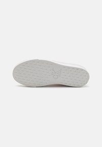 White sneaker sole with textured grip pattern, featuring a subtle CK logo. Smooth rubber material with a clean, minimalist design.