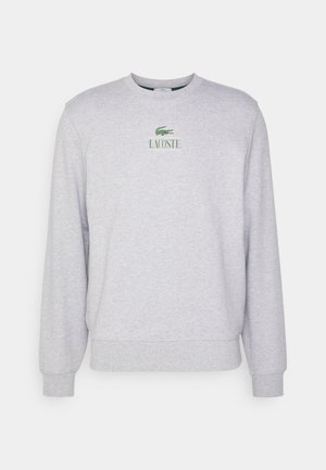 Grauer Rundhals-Sweatshirt aus weichem Stoff mit grünem gesticktem Lacoste-Logo auf der Brust sowie gerippten Bündchen und Saum.