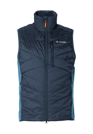 Marineblauwe geïsoleerde vest met hoge kraag, voorkant met rits en zijzakken. Beschikt over een chevron-gequilt patroon en contrasterende lichtblauwe zijkanten.