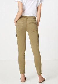 Vaaleat khaki-väriset slim cargo-housut, joissa on sivutaskut, istuva malli, puuvillamateriaali ja hienovarainen rakenne. Taaksepäin näkymä vain.