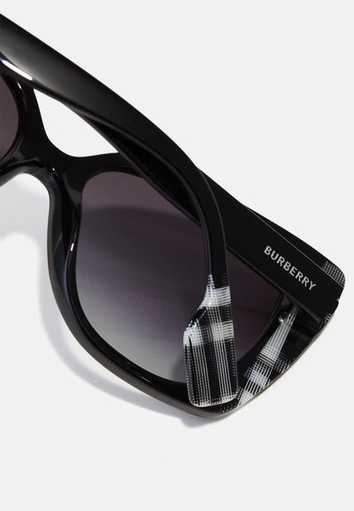 Mustad prillid gradient-läätsega, millel on läikiv raam ja must-valge ruuduline tempel, millel on graveeritud "Burberry".