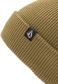 Oliven grøn strikket hue med en struktureret vævning og en foldet kant. Har et sort mærke med et hvidt geometrisk logo.