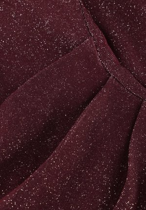 Burgundy fabric with a textured surface, featuring scattered metallic silver threads for a shimmering effect, structured in pleats.