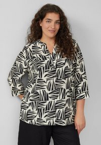 Zwart-witte blouse met een bladerenpatroon, voorzien van een V-hals en driekwartmouwen, gemaakt van lichtgewicht stof.