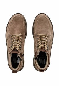 Stivaletti in suede marrone fino alla caviglia con punte tonde, lacci beige, cuciture a contrasto e occhielli in metallo. Inclusa una zip laterale per una facile calzata.