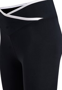 Zwarte leggings met hoge taille en een witte rand aan de tailleband met een V-vormig ontwerp aan de voorkant, gemaakt van glad, rekbaar materiaal.