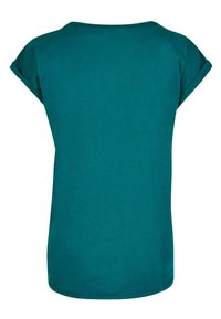 Teal lyhythihainen t-paita, jossa on pyöreä pääntie. Ominaisuuksina käännetyt hihansuut ja sileä, pehmeä rakenne. Takana pelkistetty muotoilu.