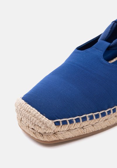 Μπλε υφασμάτινο εσπαντρίγια παπούτσι με μπεζ πλεκτή σόλα από τζούτα και καουτσούκ πάτο, κοντινή λήψη στα εμπρός και πλευρικά λεπτομέρειες.