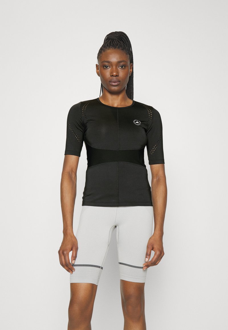 Black short-sleeve top with perforated detailing and a fitted design, paired with light gray shorts featuring dark gray stripes.