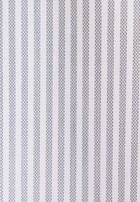 Tissu blanc avec des lignes noires verticales en pointillés régulièrement espacées formant un motif rayé.