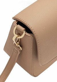 Beżowa skórzana torebka o teksturowanej powierzchni, ze złotymi akcentami i odczepianym paskiem. Posiada zaokrąglone rogi i widoczne szwy.